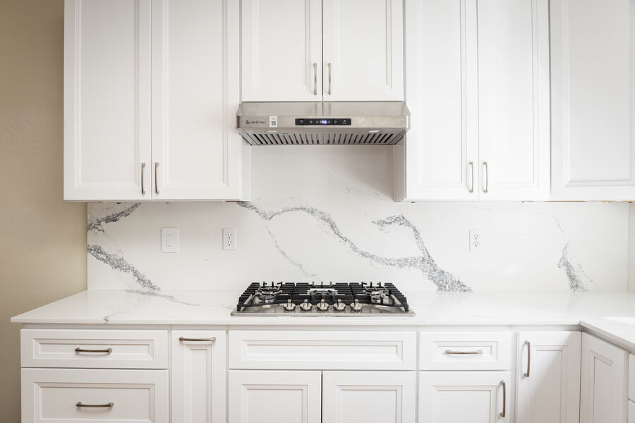 Kitchen remodel in Seattle, WA — white Shaker cabinets with quartz countertops and gas cooktop